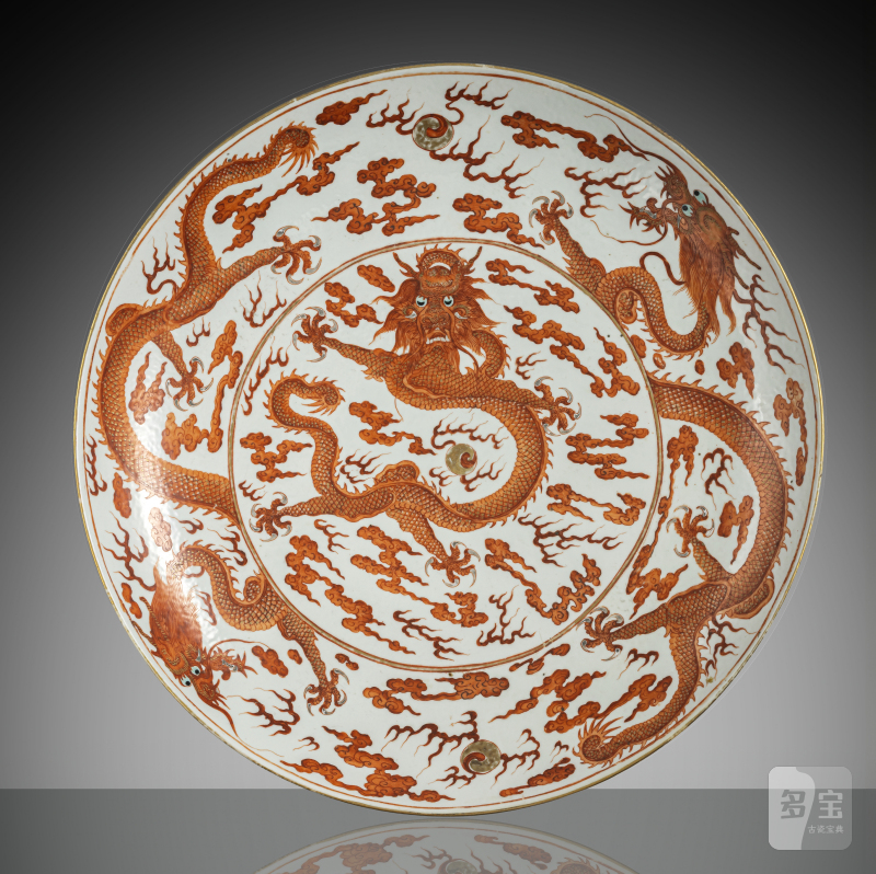 A large porcelain plate with dragon decoration in iron red and gold